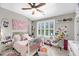 Cute bedroom with a pink floral theme, a white crib, and lots of stuffed animals on display at 160 Palm Cove Way, Mount Pleasant, SC 29466