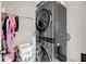 Efficient laundry room with a stacked washer and dryer, laundry baskets, and hanging storage at 160 Palm Cove Way, Mount Pleasant, SC 29466