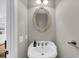 Cozy powder room featuring a pedestal sink, oval mirror and modern faucet at 160 Palm Cove Way, Mount Pleasant, SC 29466