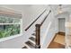 Well-lit staircase with dark wood railings and white risers, complemented by a decorative window at 160 Palm Cove Way, Mount Pleasant, SC 29466