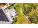 Aerial view of a landscaped backyard with a seating area, fire pit, solar panels, and lush greenery at 1714 Fort Palmetto Cir, Mount Pleasant, SC 29466