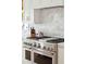 Close up on a stainless steel gas range with double ovens and marble backsplash at 1714 Fort Palmetto Cir, Mount Pleasant, SC 29466
