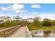 A picturesque walkway leads to waterfront homes, promising serene views and access to coastal beauty at 1714 Fort Palmetto Cir, Mount Pleasant, SC 29466