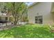 Private backyard featuring artificial turf, trees, a patio, and a glimpse of a sparkling swimming pool at 1743 Orange Grove Shores Dr, Charleston, SC 29407