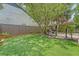 Lush backyard featuring well-maintained artificial turf, mature trees, patio, and a privacy fence at 1743 Orange Grove Shores Dr, Charleston, SC 29407