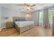 Bright bedroom with hardwood floors, ceiling fan, and a comfortable queen-sized bed with matching nightstands at 1743 Orange Grove Shores Dr, Charleston, SC 29407