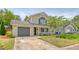 Charming two-story home featuring a cozy front porch, attached garage, and well-maintained lawn at 1743 Orange Grove Shores Dr, Charleston, SC 29407