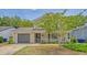 Inviting two-story home with a covered front porch, attached garage, and verdant lawn space at 1743 Orange Grove Shores Dr, Charleston, SC 29407