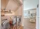 Convenient laundry area with modern washer and dryer and shelving, located off the kitchen at 1743 Orange Grove Shores Dr, Charleston, SC 29407