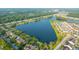 Scenic aerial view of a community with townhomes bordering a lake amidst lush green surroundings at 1751 Brittlebush Ln, Johns Island, SC 29455