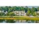 A picturesque view of townhomes overlooking the pond, surrounded by lush greenery and mature trees at 1751 Brittlebush Ln, Johns Island, SC 29455