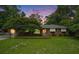 Charming brick home with manicured lawn and mature trees displayed beneath a dramatic sky at 1833 St Julian Dr, Charleston, SC 29407