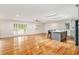 Open floor plan connecting the living area, kitchen, and sunroom with natural wood floors and neutral walls at 1833 St Julian Dr, Charleston, SC 29407