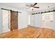 Bedroom with renovated bathroom, barn door closet, and hardwood floors at 1833 St Julian Dr, Charleston, SC 29407