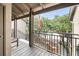 View from the balcony overlooking the street with a glimpse of neighborhood trees and sidewalk at 1948 Marsh Oak Ln, Seabrook Island, SC 29455
