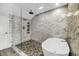 Modern bath featuring glass enclosed stone shower with stone floors and separate soaking tub at 1948 Marsh Oak Ln, Seabrook Island, SC 29455