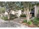 Well-maintained condo exterior with brick accents, lush landscaping, and mature trees at 1948 Marsh Oak Ln, Seabrook Island, SC 29455