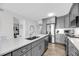 Spacious kitchen boasts stainless steel appliances, gray cabinets, quartz countertops, and a herringbone wood floor at 1948 Marsh Oak Ln, Seabrook Island, SC 29455