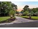 Long paved driveway lined with trees and plants leading to a charming two-story home at 2040 Shell Ring Cir, Mount Pleasant, SC 29466