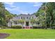 This white home has dormer windows, brick steps, a front porch, and lovely tropical trees at 2040 Shell Ring Cir, Mount Pleasant, SC 29466