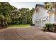 Three-car garage featuring white pergola trim and a long driveway with mature landscaping at 2040 Shell Ring Cir, Mount Pleasant, SC 29466