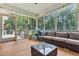 Enjoy this screened porch with comfortable wicker seating, stylish decor, and a peaceful view of the surrounding trees at 2040 Shell Ring Cir, Mount Pleasant, SC 29466