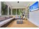 Relax on this screened-in porch with comfortable wicker seating and enjoy outdoor living with a TV and wooded views at 2040 Shell Ring Cir, Mount Pleasant, SC 29466