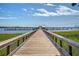 Picturesque wooden dock extending over calm water with boats and a bright blue sky at 260 Seven Farms Dr # 306, Charleston, SC 29492