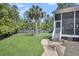 A spacious backyard featuring a palm tree, well-manicured lawn, and a screened-in porch at 2720 Oak Manor Dr, Mount Pleasant, SC 29466