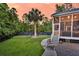 A spacious backyard featuring a palm tree, well-manicured lawn, and a screened-in porch at 2720 Oak Manor Dr, Mount Pleasant, SC 29466