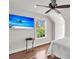 Bright bedroom featuring hardwood floors, a ceiling fan, a beach scene on TV, and a window with a green view at 2720 Oak Manor Dr, Mount Pleasant, SC 29466