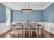 Dining room with a large wooden table, white chairs, elegant lighting, and stylish blue accent wall at 2720 Oak Manor Dr, Mount Pleasant, SC 29466