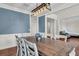 Dining room with a large wooden table, white chairs, elegant lighting, and stylish blue accent wall at 2720 Oak Manor Dr, Mount Pleasant, SC 29466