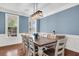 Dining room with a large wooden table, white chairs, elegant lighting, and stylish blue accent wall at 2720 Oak Manor Dr, Mount Pleasant, SC 29466