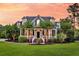 Charming two-story home features a manicured lawn, and a welcoming front porch at 2720 Oak Manor Dr, Mount Pleasant, SC 29466