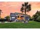 Exterior showcasing screened-in porch, patio, palm tree, and well-manicured lawn at 2720 Oak Manor Dr, Mount Pleasant, SC 29466
