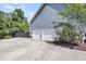 Two-car garage featuring white doors and an expansive concrete driveway, perfect for ample parking at 2720 Oak Manor Dr, Mount Pleasant, SC 29466