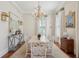 Formal dining room with wainscoting, designer chandelier, white wood table, and ample natural light at 28 Robert Mills Cir, Mount Pleasant, SC 29464