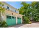 A two-car garage with bright green doors and lantern-style lighting fixtures at 28 Robert Mills Cir, Mount Pleasant, SC 29464