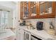 Butler's pantry features glass-front cabinets, marble countertops, wine cooler, and views to dining area at 28 Robert Mills Cir, Mount Pleasant, SC 29464