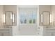 Elegant bathroom features a soaking tub, double vanities with mirrors, and natural light from the window at 2828 Wagner Way, Mount Pleasant, SC 29466