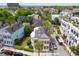 Aerial view of neighborhood showcasing yellow two-story home with double verandas and surrounding trees at 29 Smith St, Charleston, SC 29401