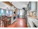 Open kitchen with exposed beams, brick accents, and a spiral staircase to the side at 29 Smith St, Charleston, SC 29401