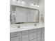 Bright bathroom featuring a gray double vanity, framed mirror, white countertop, and tiled floors at 312 Greenhouse, Summerville, SC 29485