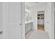 Hallway view of the bathroom featuring a vanity, framed mirror, and an open, organized closet and storage space at 312 Greenhouse, Summerville, SC 29485