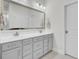 Bright bathroom featuring a gray double vanity, framed mirror, white countertop, and tiled floors at 312 Greenhouse, Summerville, SC 29485