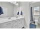 Bathroom featuring a double vanity with white cabinets, a large mirror and a shower and toilet in the background at 312 Greenhouse, Summerville, SC 29485