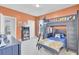 A bedroom with orange walls featuring a bunkbed with a ladder, desk and shelving at 312 Greenhouse, Summerville, SC 29485