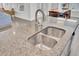 Close-up of kitchen island with stainless steel sink and granite countertop, adjacent to dining area at 312 Greenhouse, Summerville, SC 29485