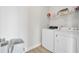 Bright laundry room featuring white washer and dryer, storage shelf, and neutral walls with light wood flooring at 312 Greenhouse, Summerville, SC 29485